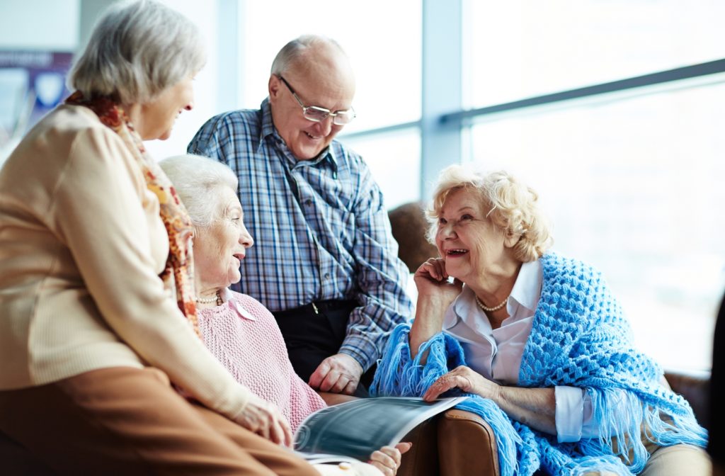 A group of four seniors talking amongst each other in an assisted living community