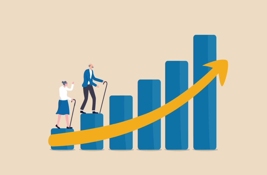 An infographic photo with a drawing of a female and a male senior stepping on the blue columns with a yellow arrow pointing upwards indicating the growing population of seniors.