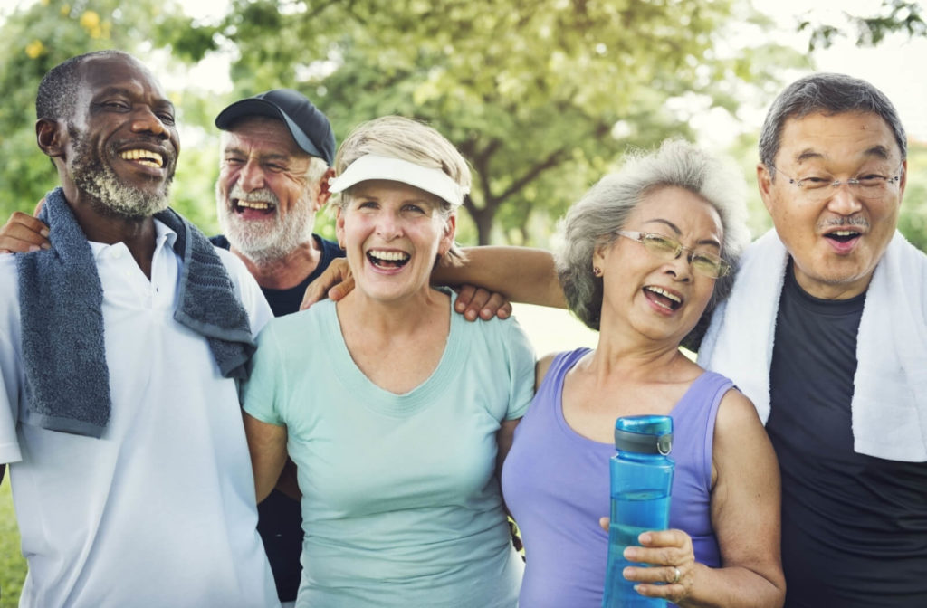 A group of active seniors smiling after a morning exercise outdoors