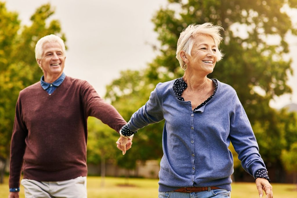 Active senior couple happily going for a walk together in nature