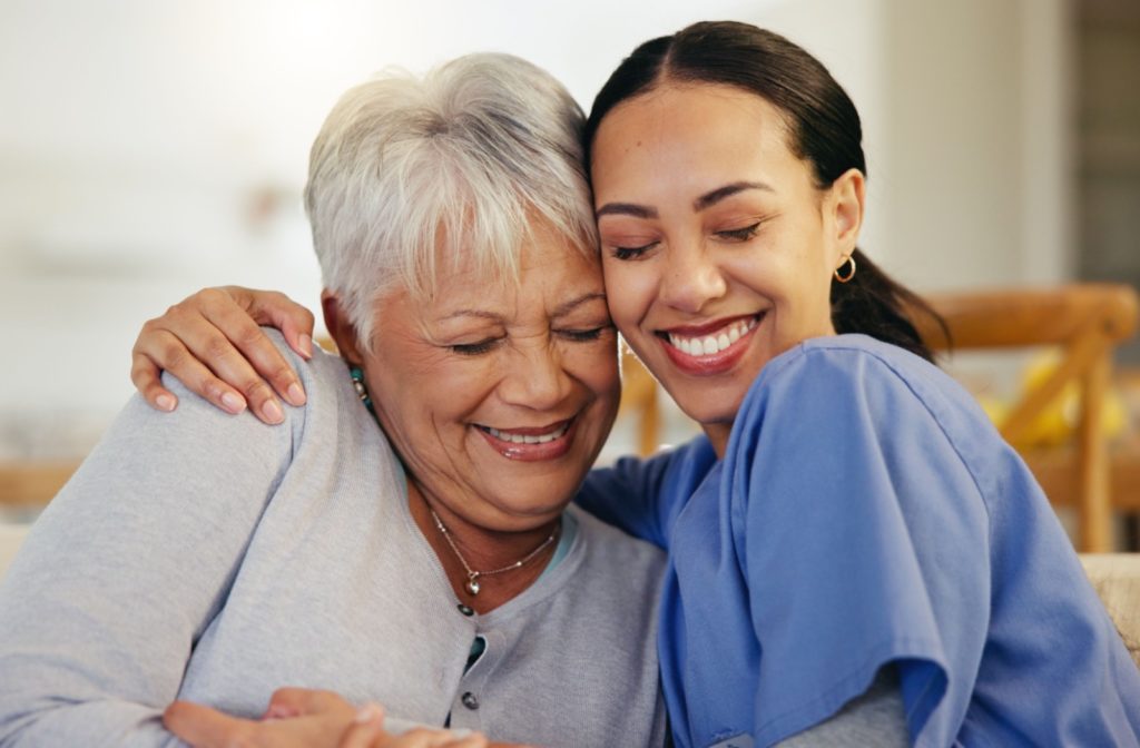 Smiling woman celebrating her new job in a senior living community with a patient.