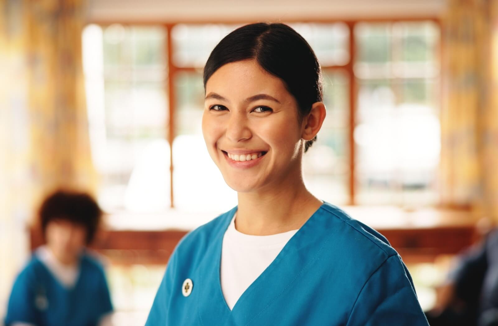 A smiling caregiver in assisted living is glad they chose a career in senior living.