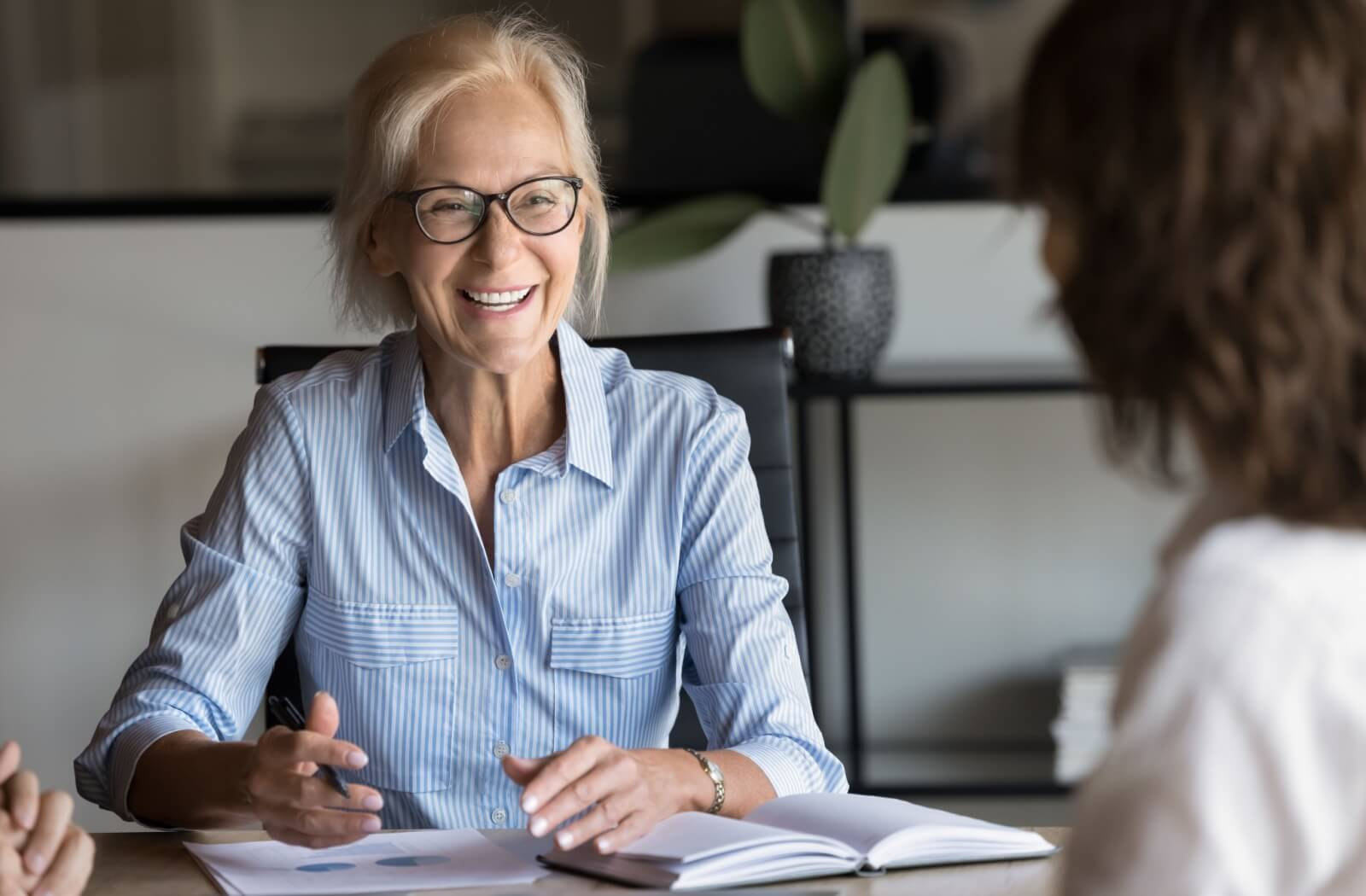 A smiling business owner engages in positive conversation with clients while sharing information.